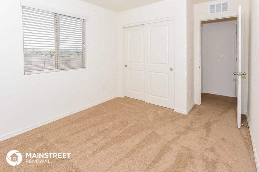 the living room of an apartment with a door and a window