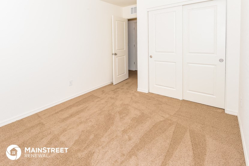 a bedroom with a carpeted floor and white doors