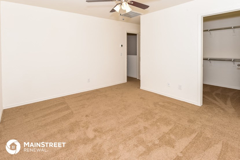an empty room with a closet and a ceiling fan