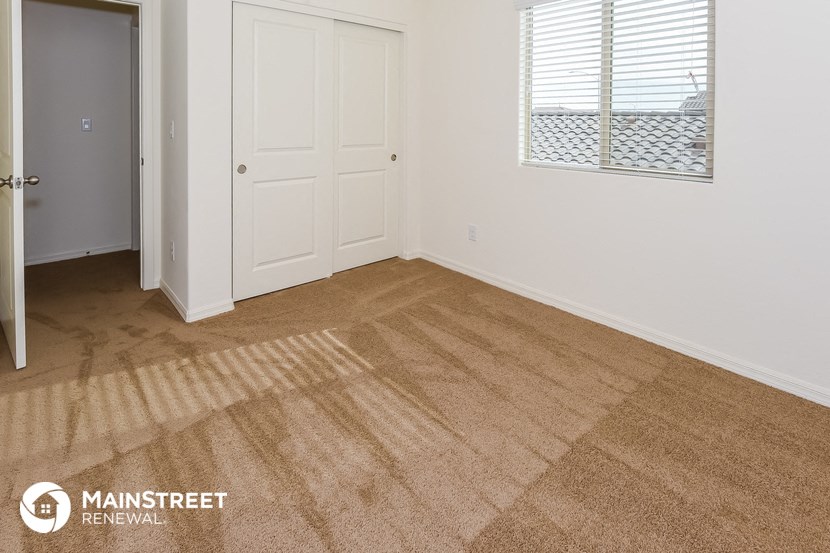 a room with a carpeted floor and a door and a window