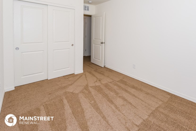 a bedroom with a carpeted floor and white doors