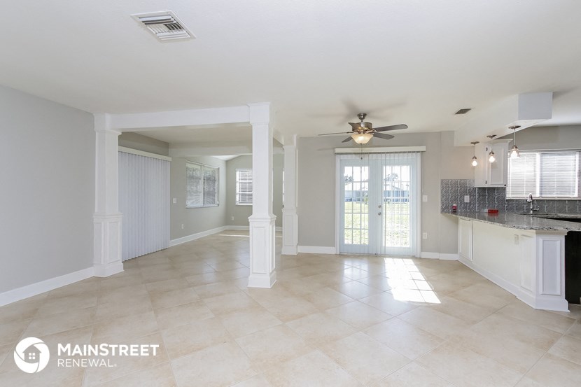 a kitchen and living room with a ceiling fan