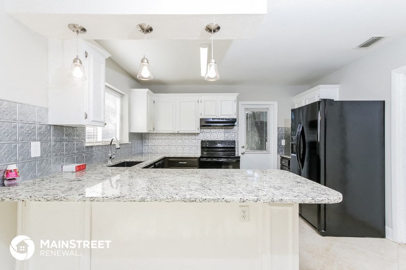 a kitchen with granite counter tops and black appliances