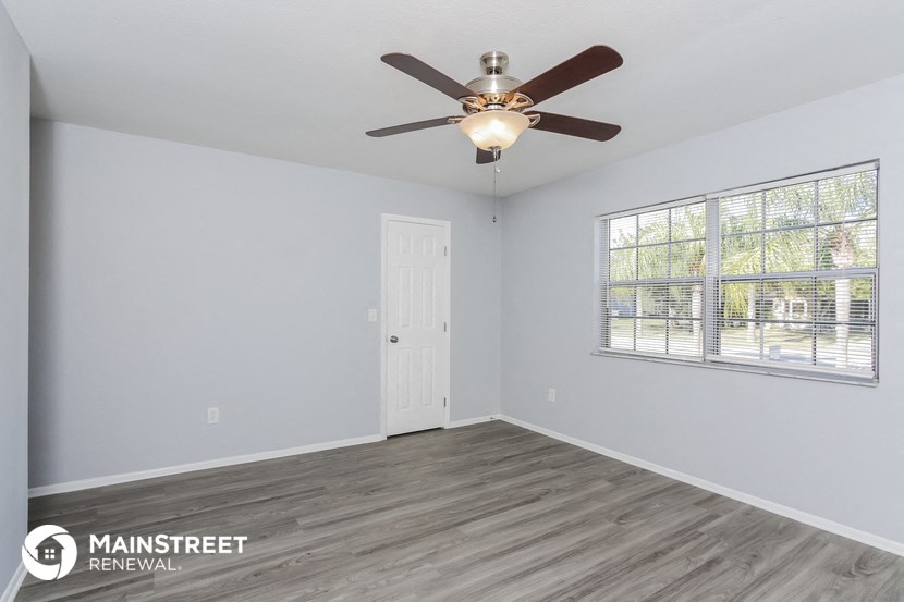 the living room of an empty house with a ceiling fan