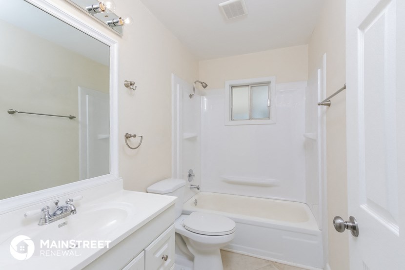 a white bathroom with a white toilet and a tub and a sink