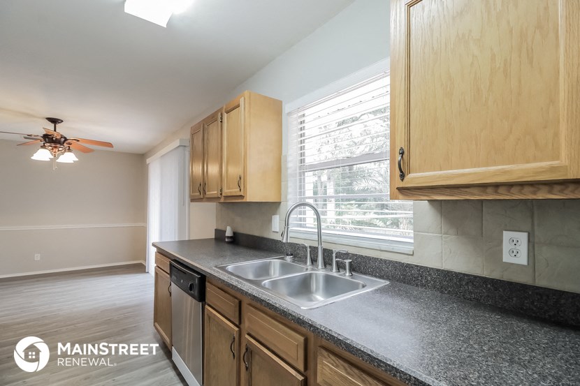 a kitchen with wood cabinets and a sink and a window