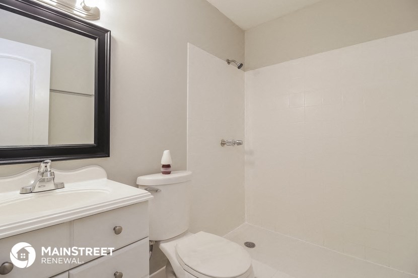 a bathroom with a toilet and a sink and a mirror