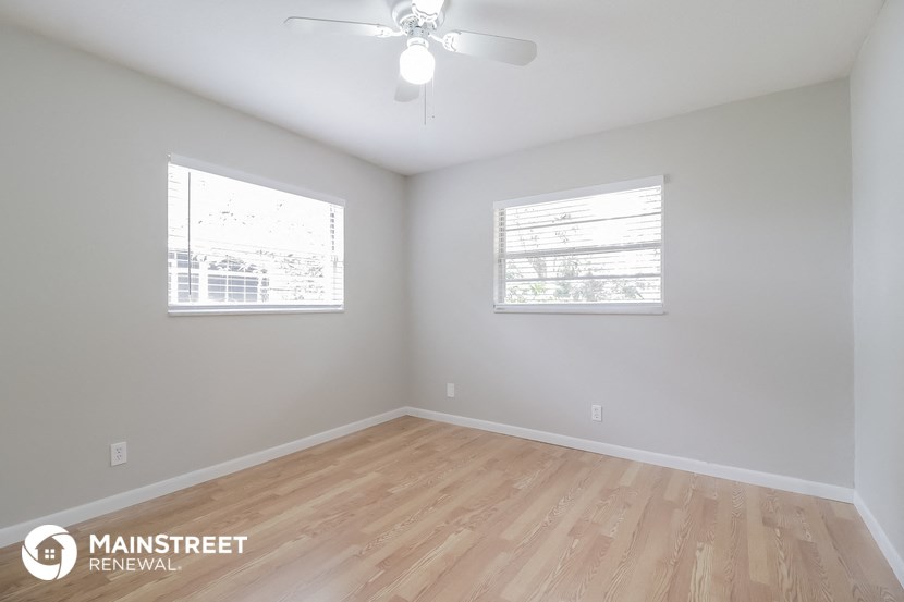 the living room of a new home with wood flooring and a ceiling fan