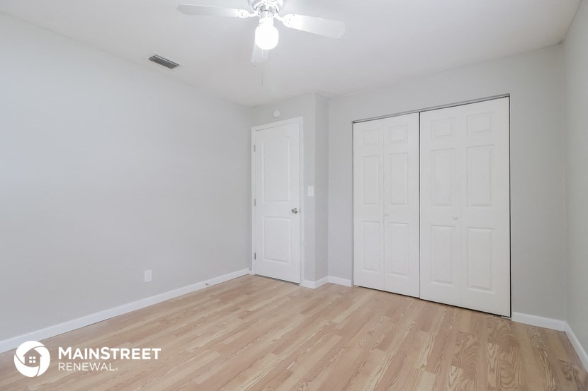 the master bedroom of this 2500sf renovated house has a hardwood floor and white
