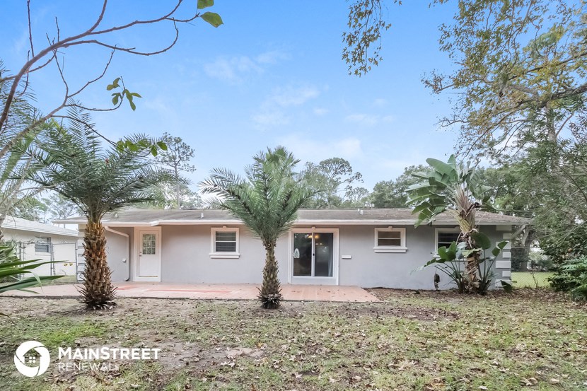 a white house with palm trees in front of it