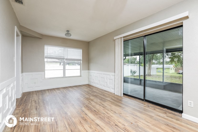 an empty living room with wood flooring and sliding glass doors