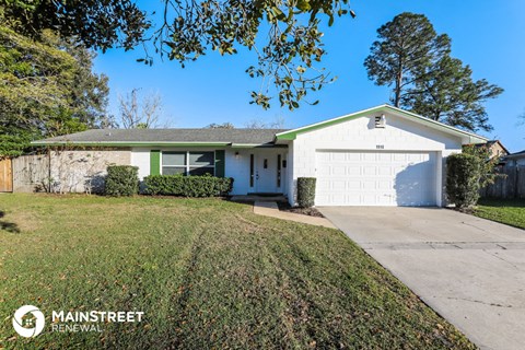 a small white house with a driveway and a garage door