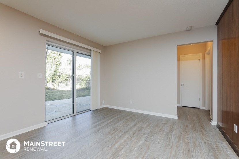 an empty living room with wood floors and sliding glass doors