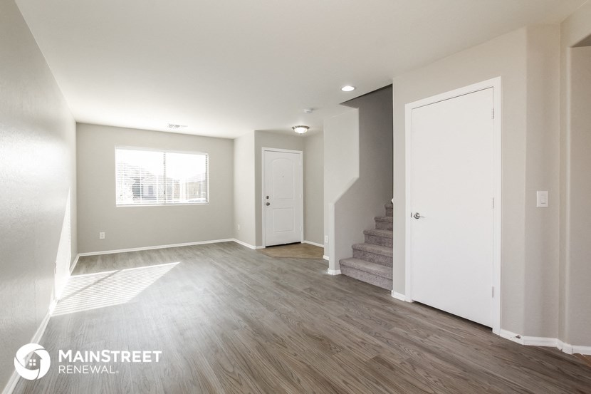 the living room and entryway of an apartment