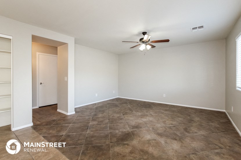 the spacious living room with tile flooring and a ceiling fan