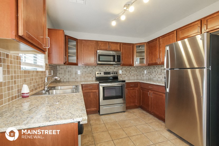 a kitchen with wooden cabinets and stainless steel appliances