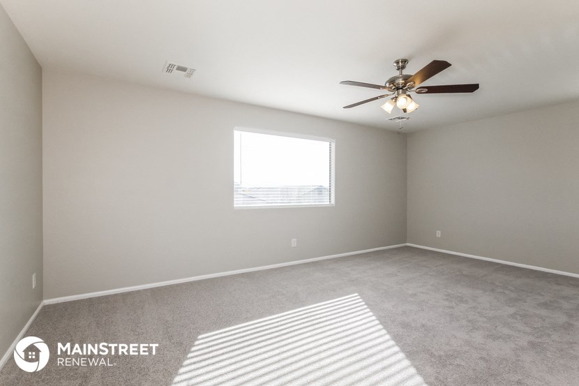 an empty room with a ceiling fan and a window