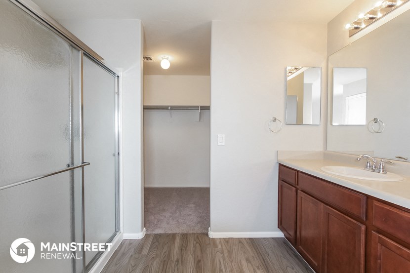 a bathroom with a shower and a sink and a mirror