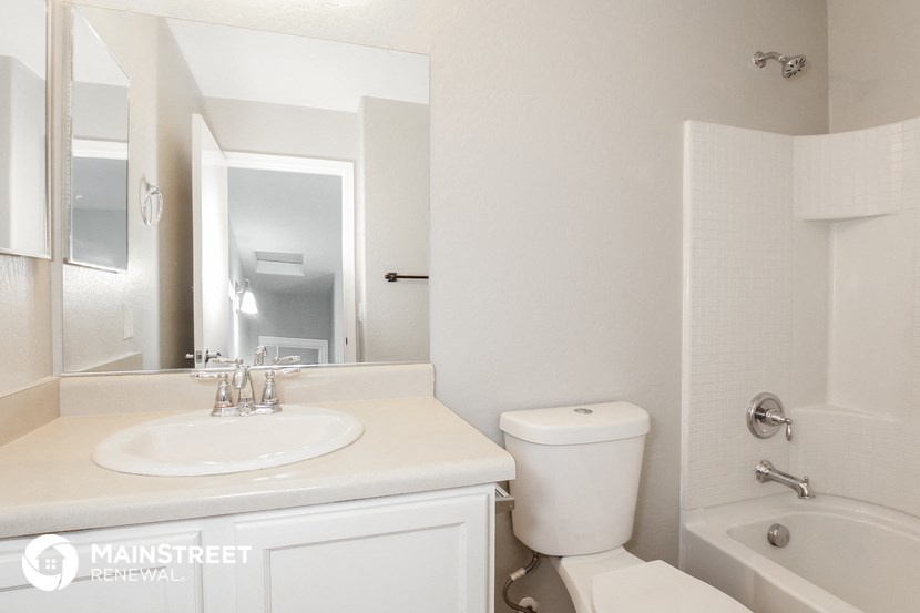 a white bathroom with a white sink and toilet and a tub