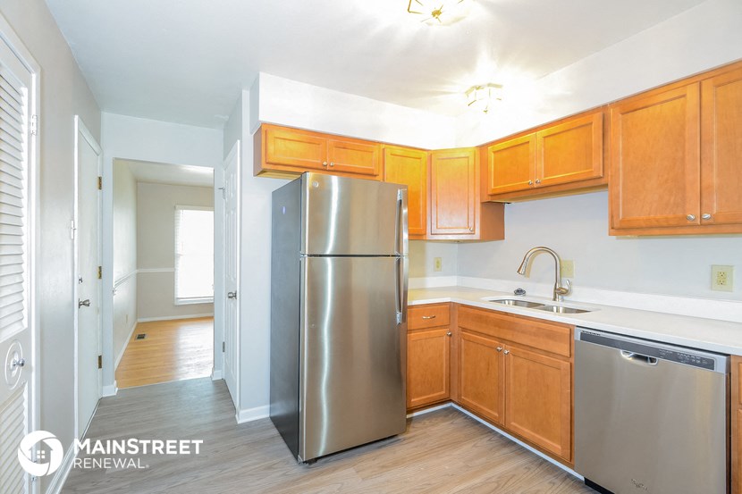 a kitchen with wooden cabinets and a stainless steel refrigerator