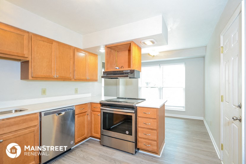 the kitchen of an apartment with wooden cabinets and stainless steel appliances