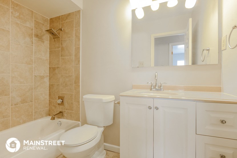 a bathroom with a toilet sink and tub and a mirror