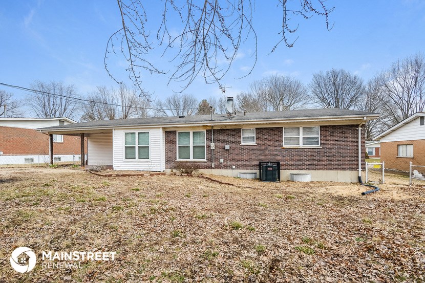 a small brick house with a yard in front of it