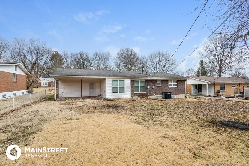 a small brick house with a yard in front of it