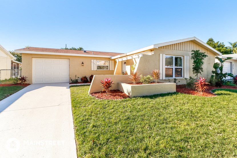 a beige house with a lawn and a white garage door