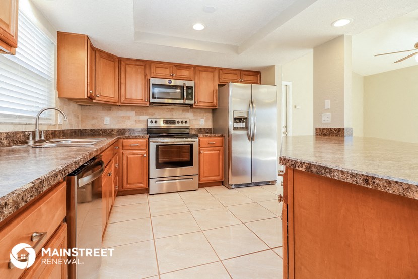 a large kitchen with wooden cabinets and stainless steel appliances