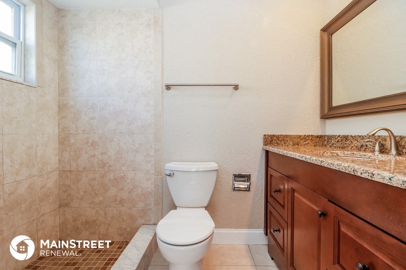 a bathroom with a toilet and a sink and a mirror