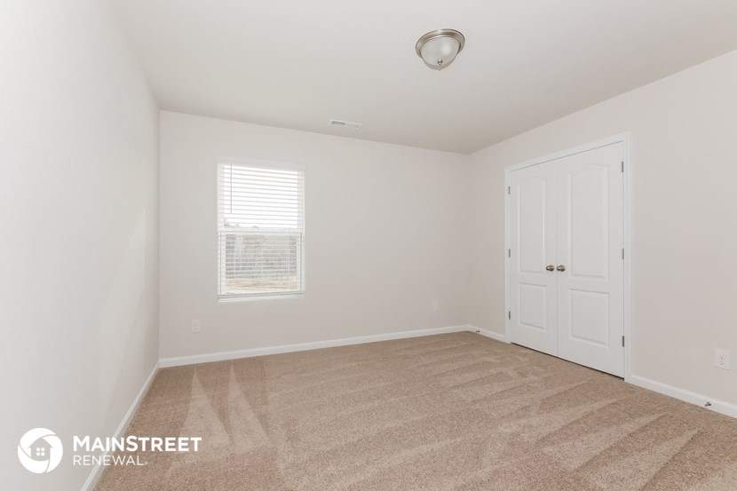 a bedroom with a carpeted floor and a white door