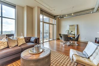 Spacious open concept floor plans with large living room and dining area with hardwood style flooring Spacious open concept floor plans with large living room and dining area with hardwood style flooring