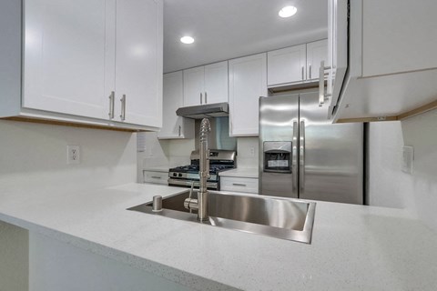 the kitchen has stainless steel appliances and white cabinets