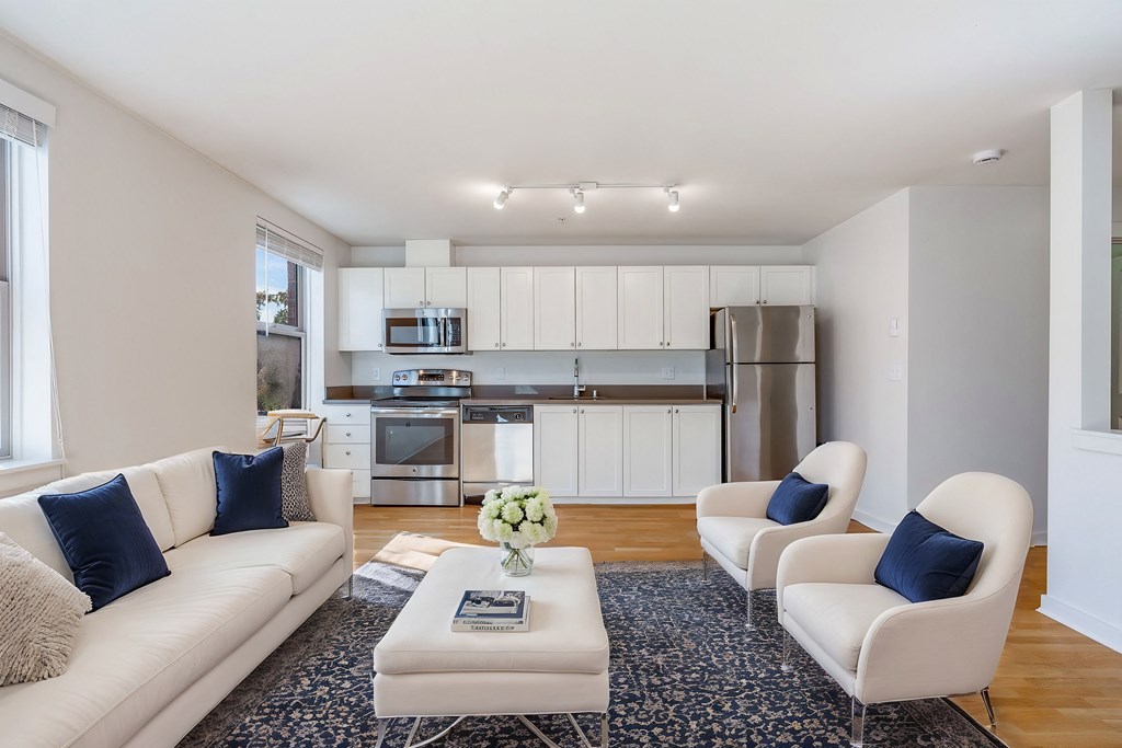 a living room with a couch and a coffee table and a kitchen