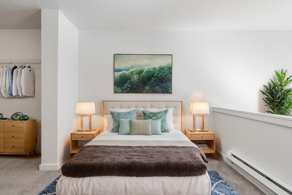 a bedroom with a bed and a painting on the wall