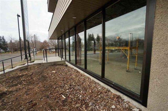 a building with large windows and a dirt area outside