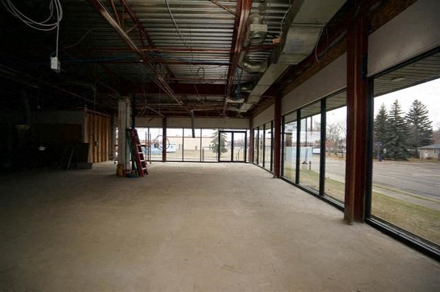a large empty room with glass windows and a concrete floor