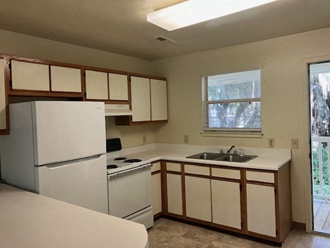 A kitchen with white appliances and wooden cabinets.