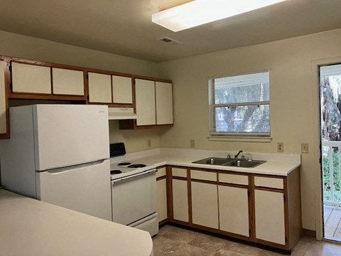 a kitchen with a white refrigerator and a sink