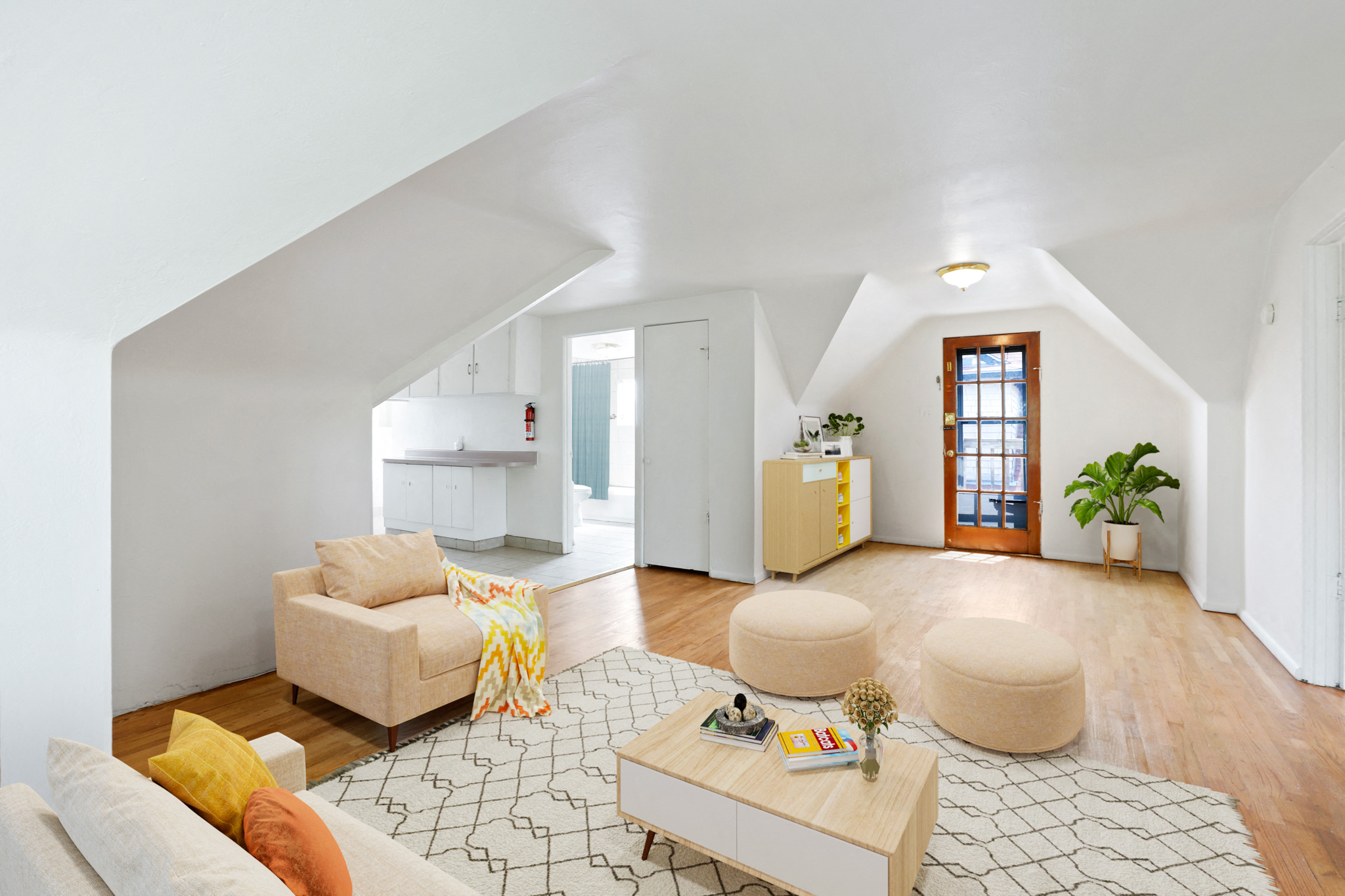 a living room with a couch and a coffee table and a kitchen
