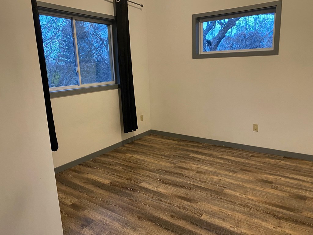 a living room with wood floors and a window