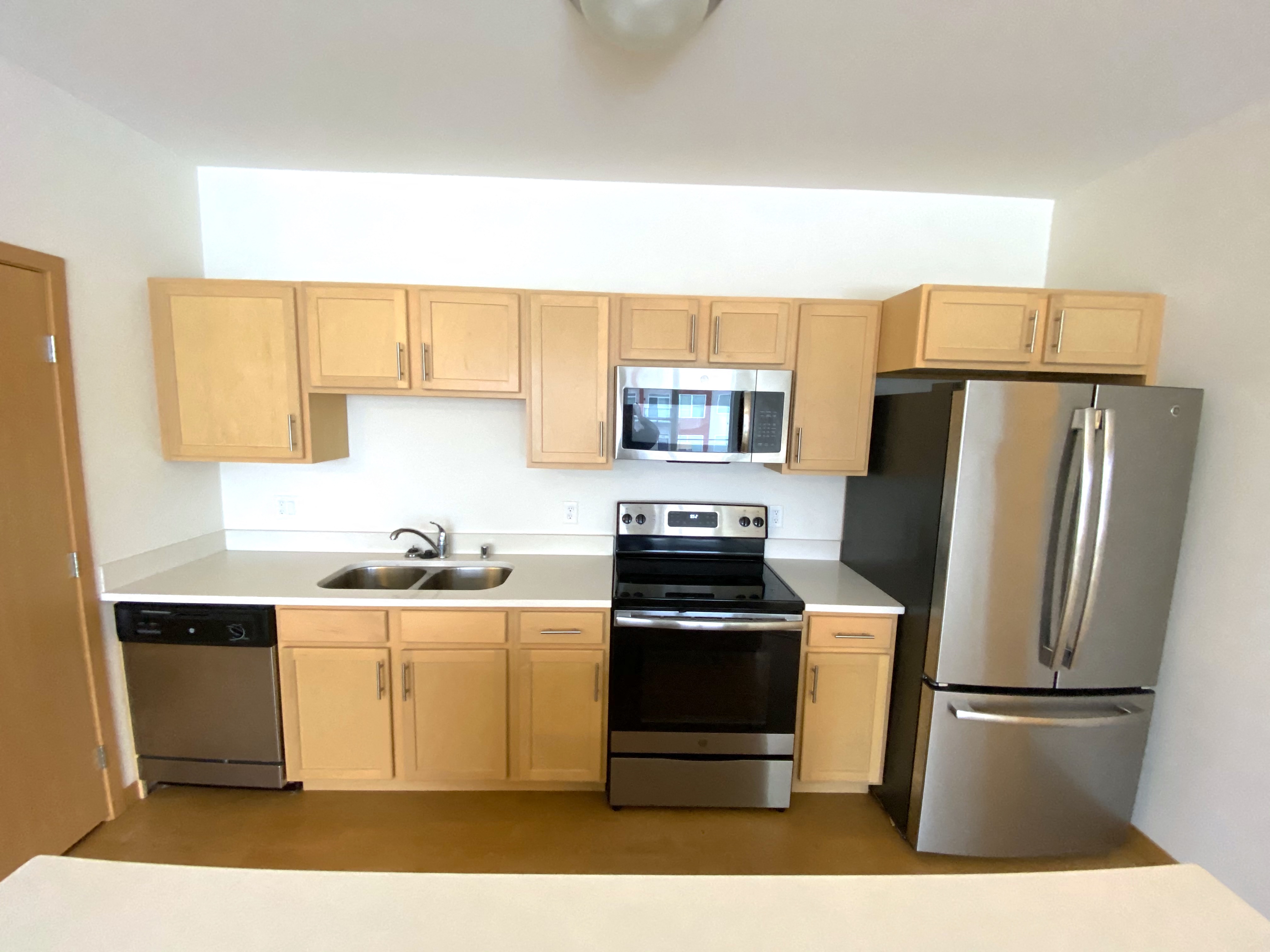 A kitchen with wooden cabinets and stainless steel appliances.