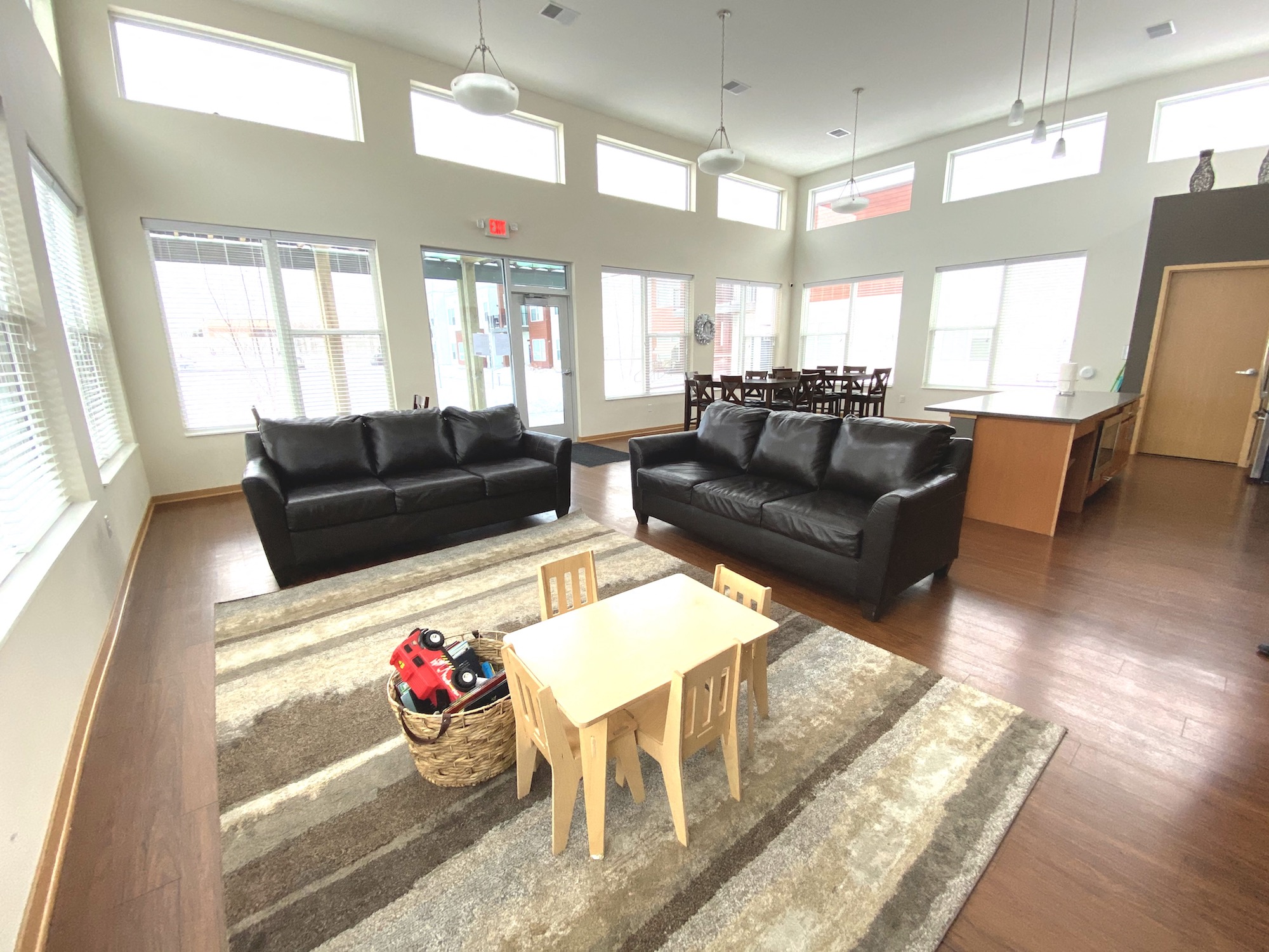 A living room with a black couch and a wooden table.