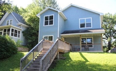 a blue house with a porch and a wooden deck
