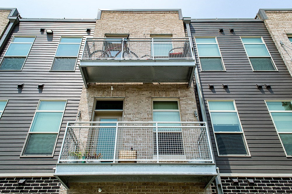 an apartment building with a balcony and a brick facade