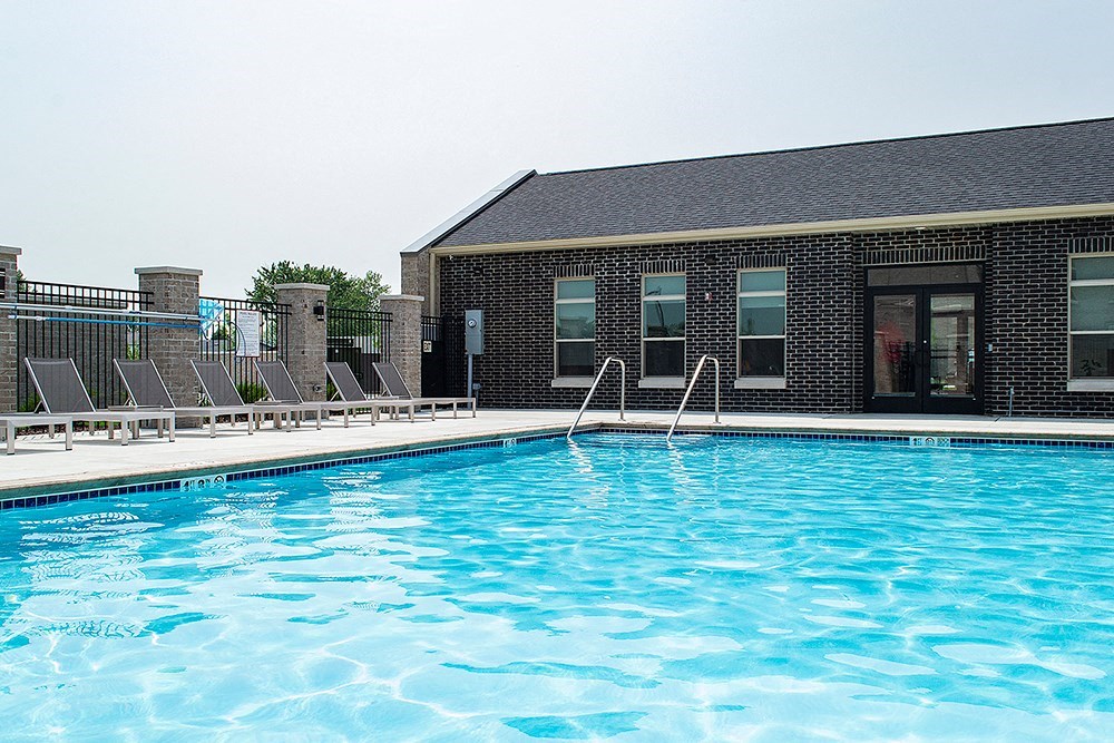 a swimming pool in front of a brick building