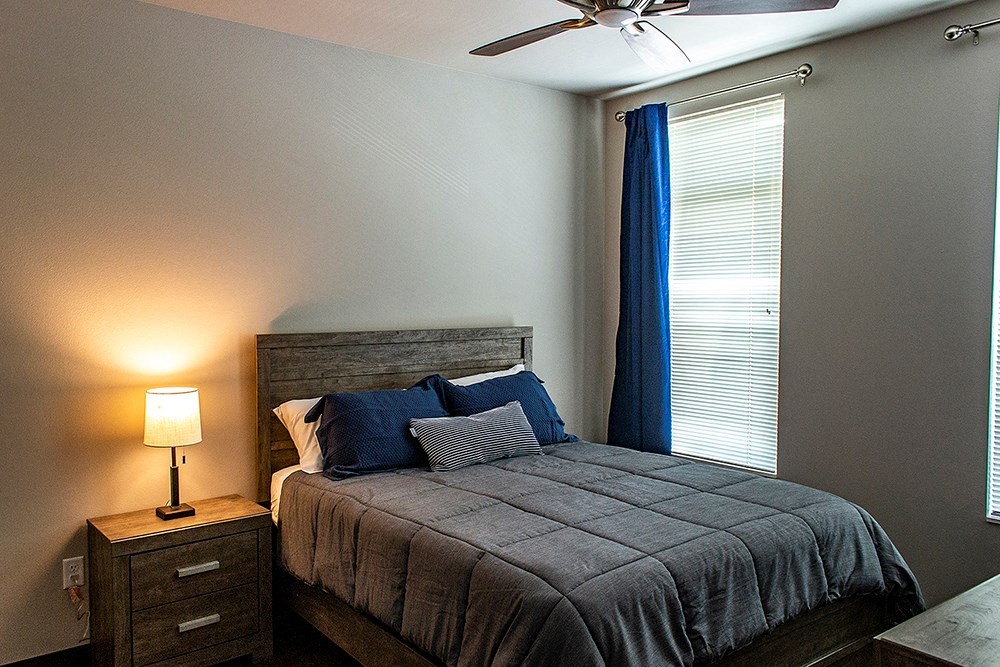 a bedroom with a bed and a ceiling fan
