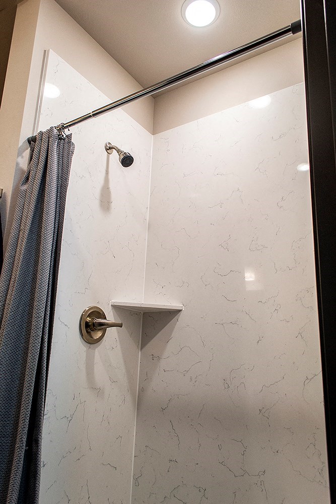a white bathroom with a shower and a curtain