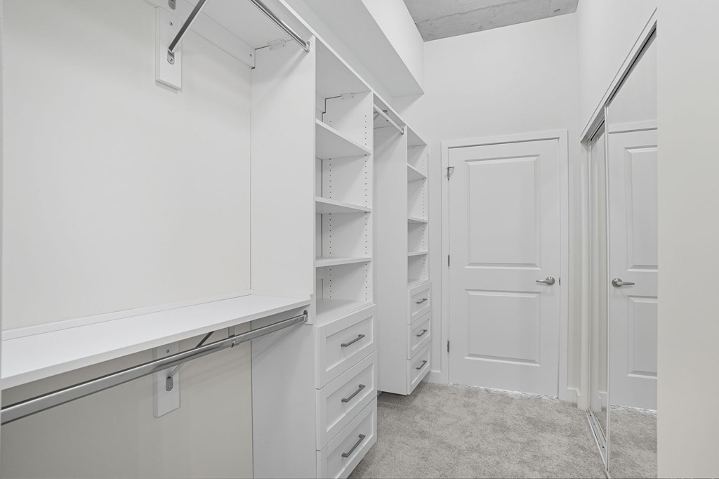 A white pantry with shelves and drawers.